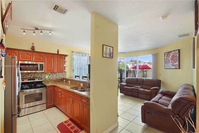 kitchen featuring decorative backsplash, light tile patterned flooring, sink, and appliances with stainless steel finishes