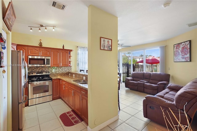 kitchen featuring backsplash, sink, ceiling fan, light tile patterned floors, and appliances with stainless steel finishes