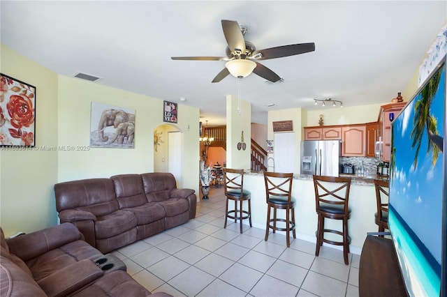 living room with light tile patterned floors and ceiling fan with notable chandelier