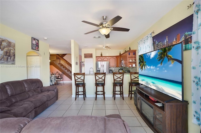 living room featuring ceiling fan, light tile patterned flooring, and sink