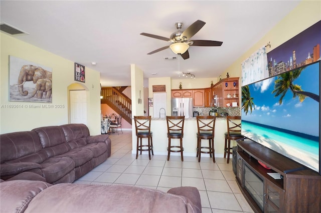 living room featuring ceiling fan, light tile patterned flooring, and sink