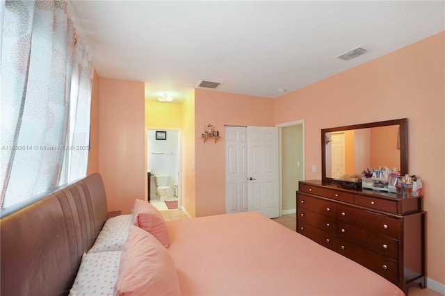 bedroom featuring light tile patterned floors and ensuite bath