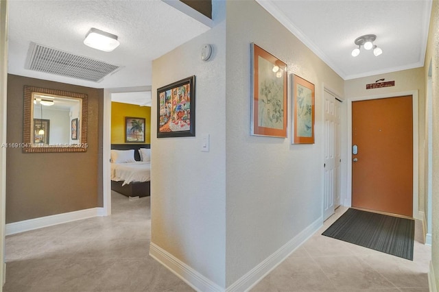 hall featuring light tile patterned floors, a textured ceiling, and ornamental molding