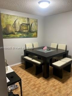 dining area with tile patterned floors and a textured ceiling