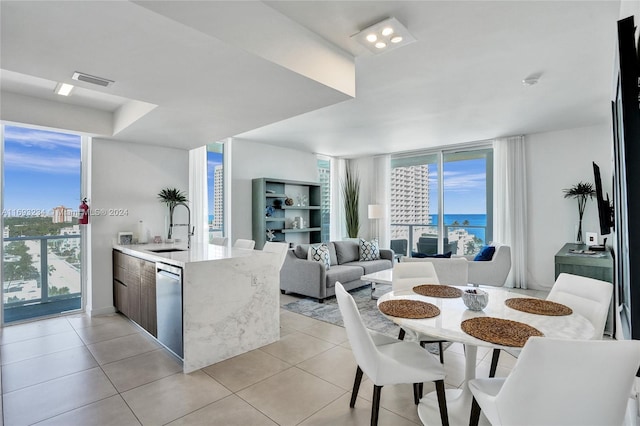 kitchen featuring dishwasher, kitchen peninsula, light tile patterned flooring, and sink