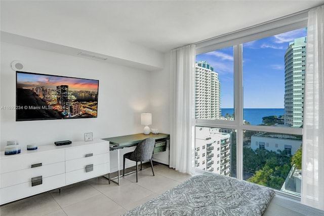 tiled bedroom featuring a water view and multiple windows