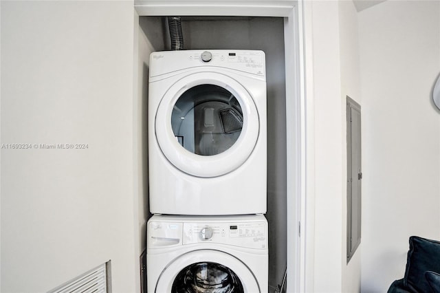 clothes washing area featuring stacked washer and clothes dryer