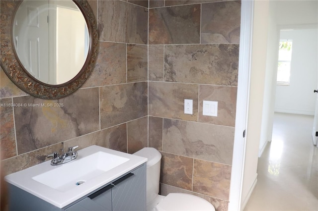 bathroom with toilet, tile walls, backsplash, and vanity