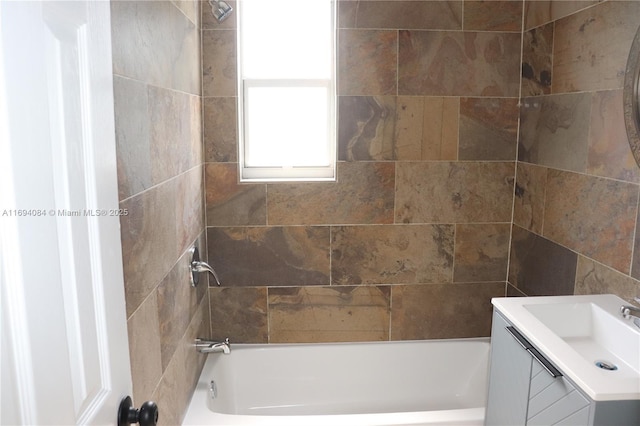 bathroom with tiled shower / bath and vanity