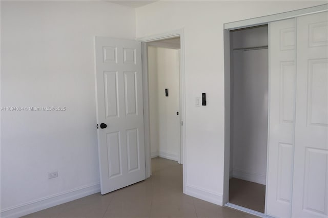 unfurnished bedroom with a closet and tile patterned flooring