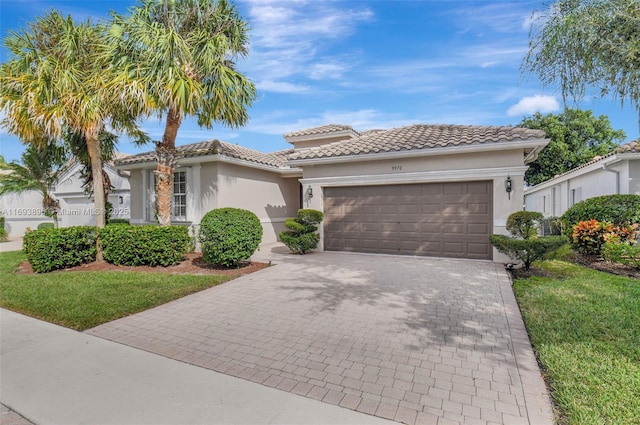 mediterranean / spanish-style house with a garage and a front lawn