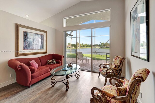 interior space featuring hardwood / wood-style floors, a water view, and lofted ceiling