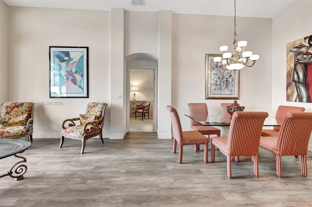 dining space featuring hardwood / wood-style flooring and a notable chandelier