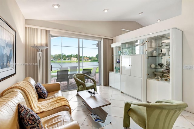 living room featuring vaulted ceiling, a water view, and light tile patterned floors