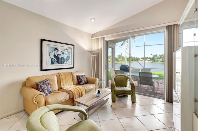 living room featuring lofted ceiling, a water view, and light tile patterned flooring