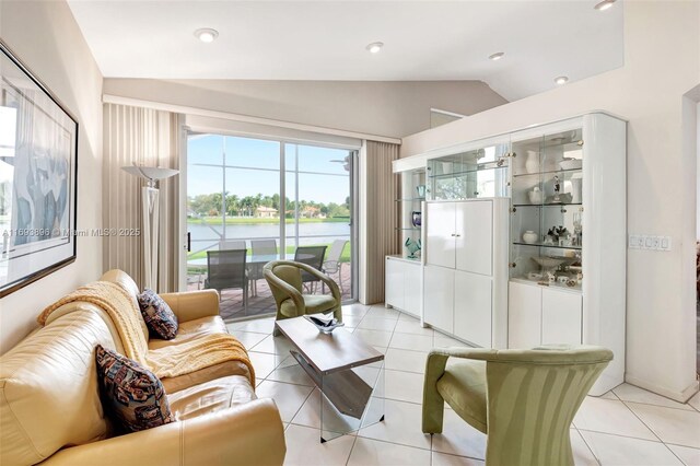 living room featuring a water view, light tile patterned floors, and lofted ceiling