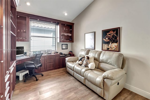 office space with light wood-type flooring and vaulted ceiling