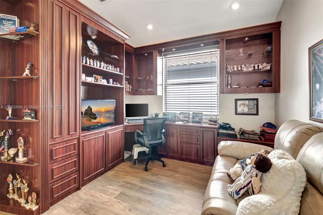 office area with built in desk and light hardwood / wood-style floors