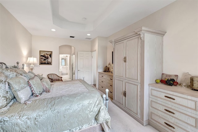 carpeted bedroom featuring connected bathroom and a raised ceiling