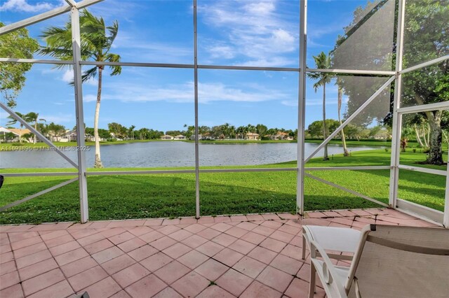 unfurnished sunroom featuring a water view and plenty of natural light