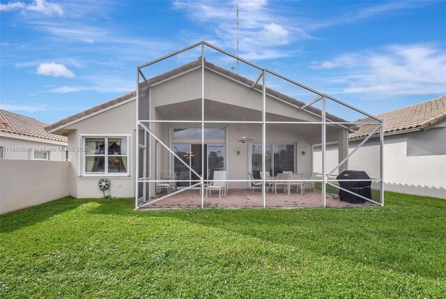 back of property with a lanai, a yard, and a patio