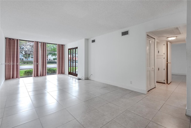 tiled empty room with a textured ceiling