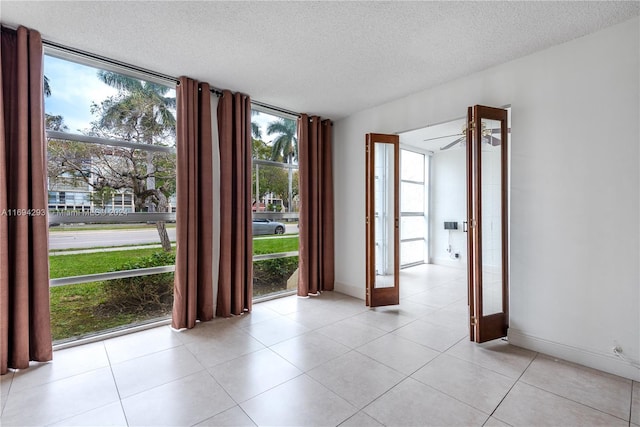 2000 Atlantic Shores Blvd Unit 107, Hallandale Beach, FL 33009 - spare room with plenty of natural light, a textured ceiling, expansive windows, light tile patterned floors, and baseboards