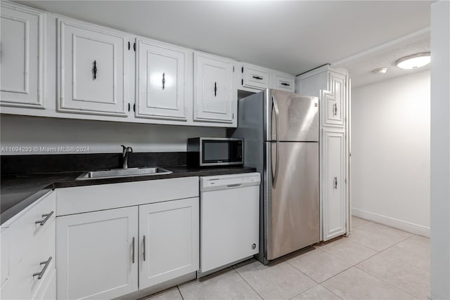 2000 Atlantic Shores Blvd Unit 107, Hallandale Beach, FL 33009 - kitchen with appliances with stainless steel finishes, a sink, white cabinets, dark countertops, and light tile patterned floors