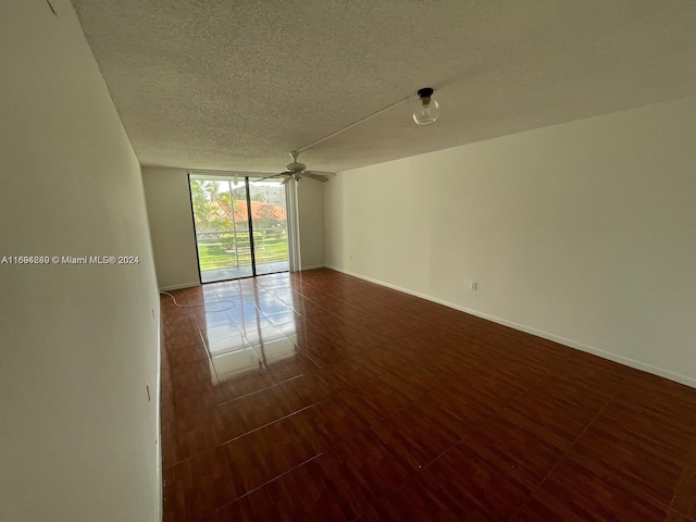 unfurnished room featuring ceiling fan, dark hardwood / wood-style flooring, and a textured ceiling