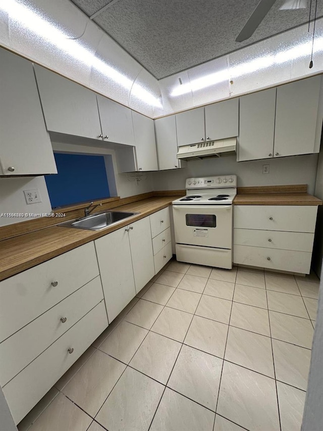 kitchen with white cabinetry, sink, white electric stove, butcher block countertops, and light tile patterned floors