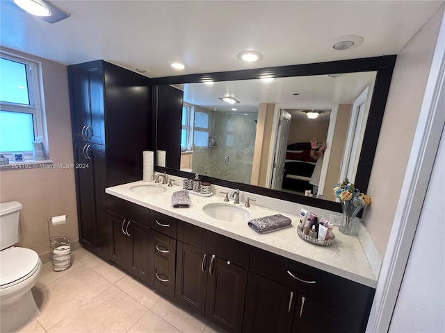 bathroom with tile patterned flooring, vanity, toilet, and a shower with shower door