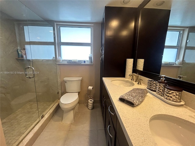 bathroom featuring tile patterned flooring, vanity, toilet, and a shower with door