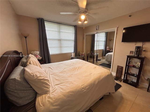 bedroom featuring tile patterned flooring, ceiling fan, and a textured ceiling