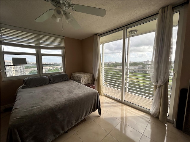 bedroom featuring ceiling fan, light tile patterned flooring, a textured ceiling, and access to outside