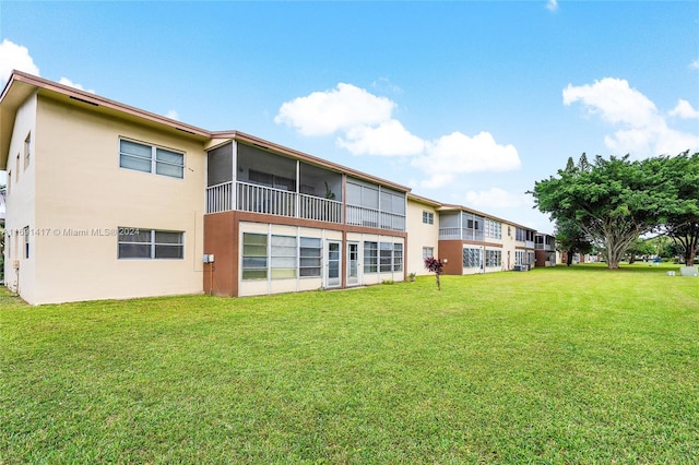 rear view of property featuring a lawn