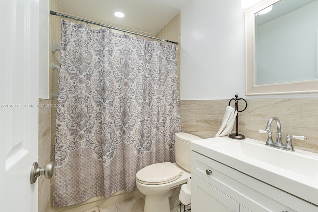 bathroom featuring vanity, toilet, and tile walls