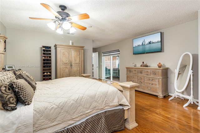 bedroom featuring a textured ceiling, light wood-type flooring, and ceiling fan