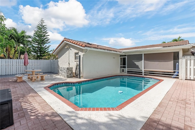 view of pool featuring a patio area and a sunroom