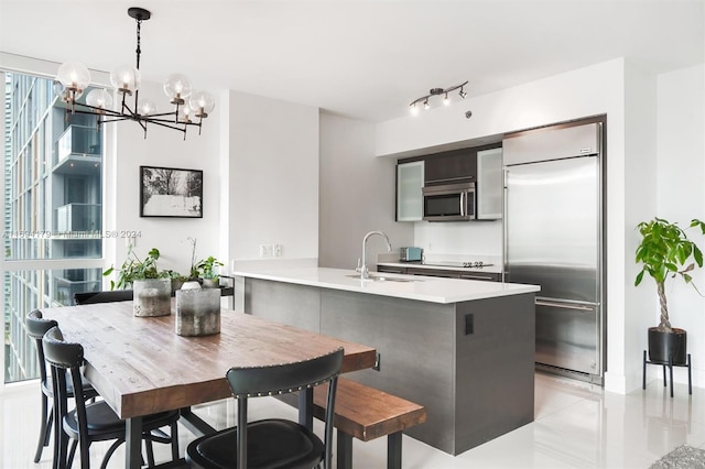 kitchen with a healthy amount of sunlight, sink, stainless steel appliances, and an inviting chandelier