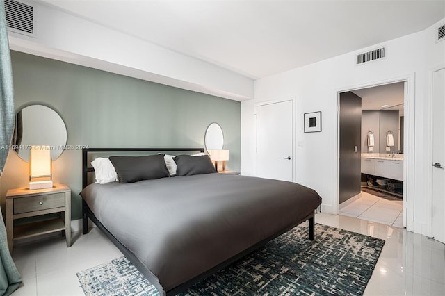 bedroom with connected bathroom and tile patterned flooring