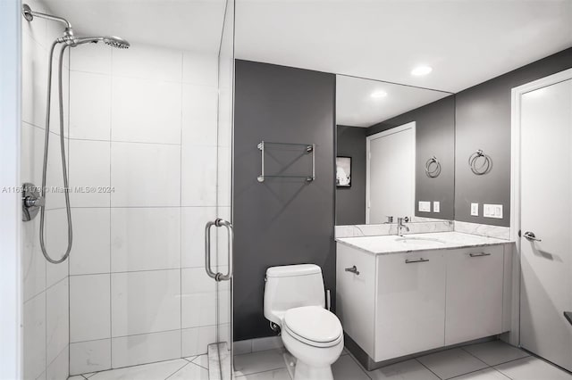 bathroom with tile patterned flooring, vanity, toilet, and a shower with door