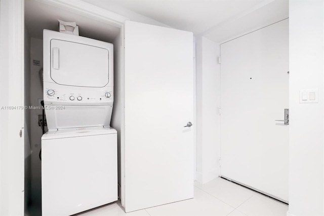 laundry room featuring light tile patterned floors and stacked washing maching and dryer