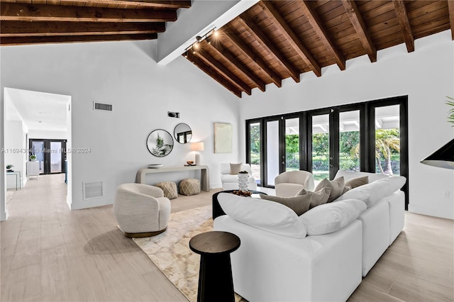 living room featuring beam ceiling, plenty of natural light, high vaulted ceiling, and light hardwood / wood-style flooring