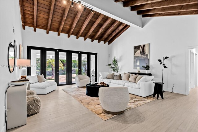 living room featuring high vaulted ceiling, french doors, light hardwood / wood-style flooring, beam ceiling, and wood ceiling