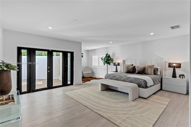 bedroom featuring french doors, light wood-type flooring, access to outside, and multiple windows