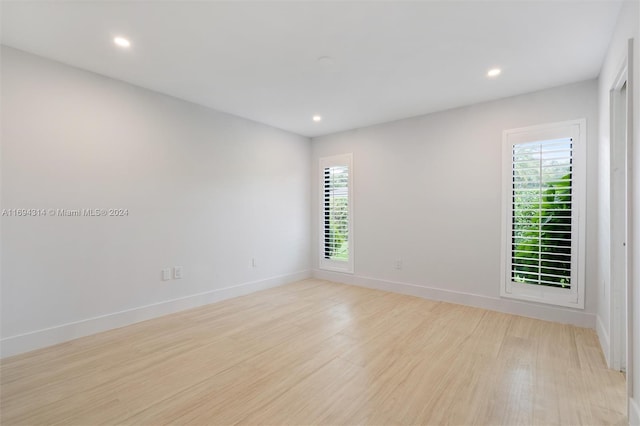 spare room featuring a healthy amount of sunlight and light hardwood / wood-style floors