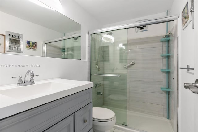 bathroom with walk in shower, vanity, and toilet