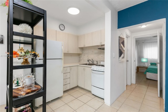 kitchen featuring sink, tasteful backsplash, cream cabinets, white appliances, and light tile patterned floors