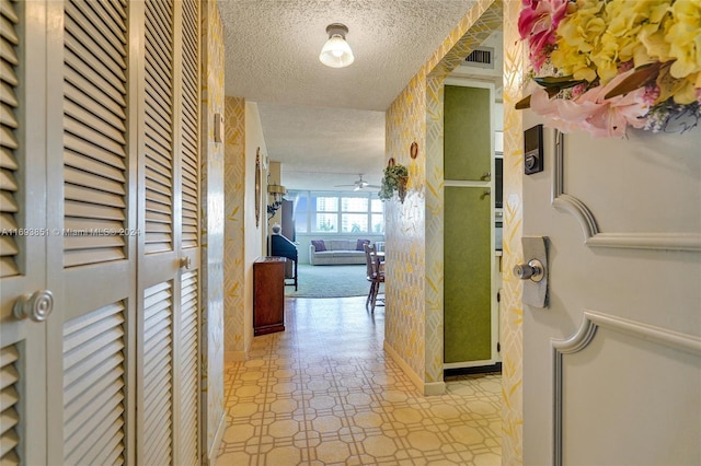 hallway with a textured ceiling