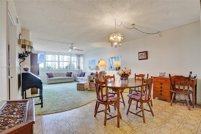 dining room featuring light carpet, ceiling fan with notable chandelier, and a textured ceiling